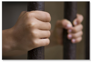 Hands holding jail cell bars
