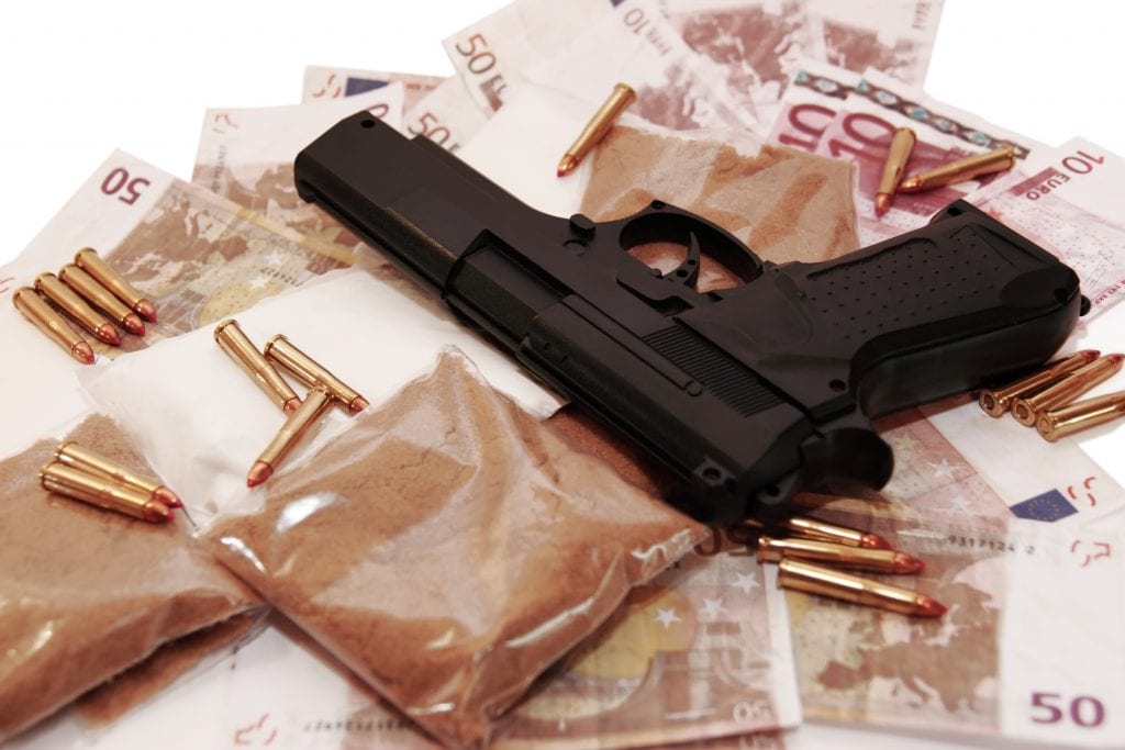 drugs and gun on scattered bank notes