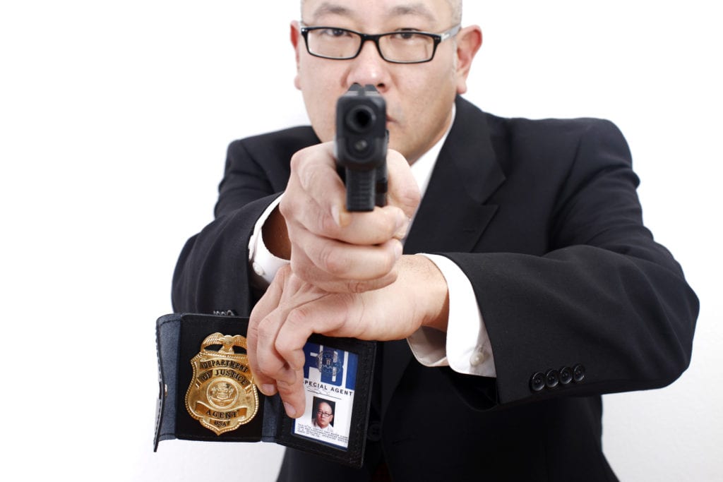 Officer holding a gun and badge