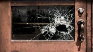 a glass door with a big smash in it where someone tried to break in.